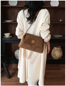 Chic brown shoulder bag detail featuring luxury double ring clasp and elegant metal strap.