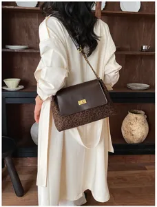 Detailed view of a brown leopard print leather shoulder bag with chic metal chain strap.