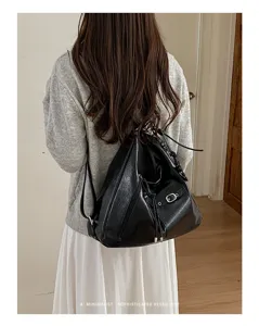Detailed shot of a black soft leather backpack, vintage retro aesthetic casual bag.