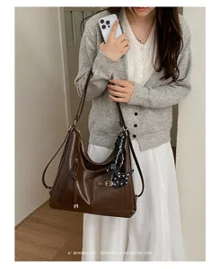Retro brown leather tote bag detail showing large capacity and elegant shoulder design.