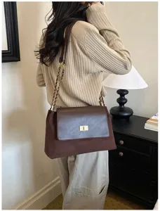 Detailed view of stylish brown suede shoulder bag with chic metal lock and chain strap.