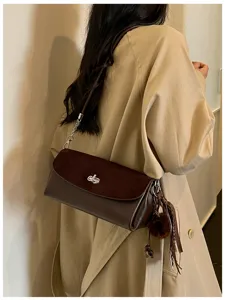 Chic brown suede flap shoulder bag with metallic twist lock and cute furry pendant.