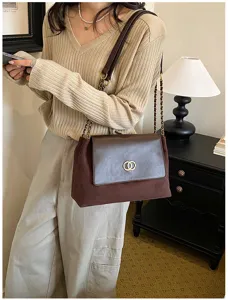 Brown suede leather shoulder bag detail, elegant chain strap and metal lock design.
