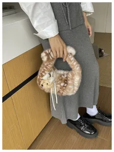 Detalle de bolso de peluche suave con diseño de ciervo y colgante de osito tierno.