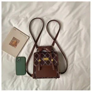 Detailed view of a chic brown quilted mini backpack with bow detail and slim straps.