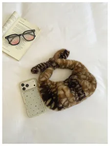 Primer plano del bolso hobo de peluche suave con estampado de ciervo, detalle de otoño.