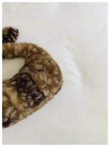 Vista detallada del bolso dumpling de piel sintética afelpada con textura de patrón de ciervo.