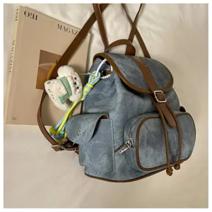 Casual denim backpack for women, stylish vintage school bookbag with brown leather trim and cute charm.