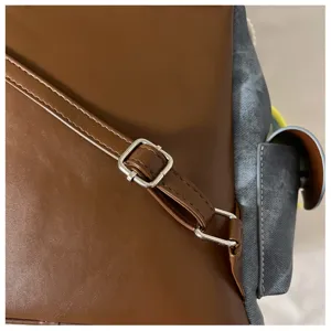 Close-up detail of stylish women backpack strap, metal buckle, durable stitching design.