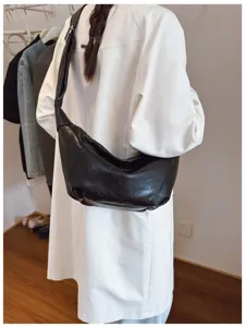 Gedetailleerd overzicht van de zwarte, slappe lederen knoedeltas met textuur en stijl.