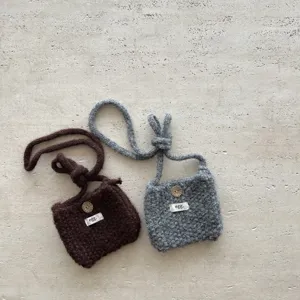 Vue rapprochée du mini sac bandoulière tricoté main en douce laine avec beau bouton.