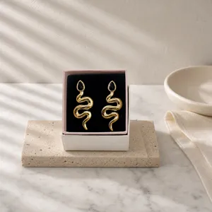 Vintage gold snake earrings with black teardrop gemstone in luxury jewelry gift box.