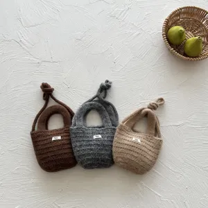 Details of cute handmade knitted children messenger bags in three solid colors for autumn winter.