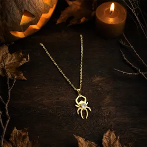 Halloween gothic style gold spider necklace close-up, sparkling crystal pendant detail.
