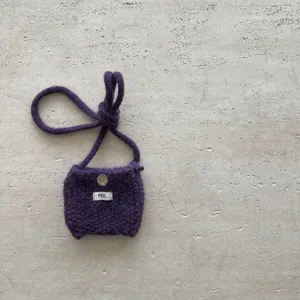 Vue détaillée du mini sac bandoulière en tricot violet fait main avec un bouton en bois.