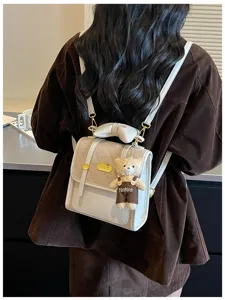 Chic women's mini backpack detail shot, stylish beige daily commute designer school bag.