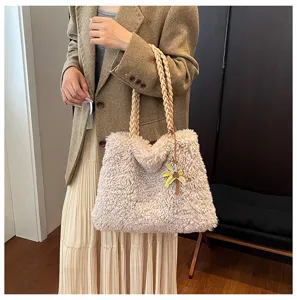 Detalle de elegante bolso de hombro de felpa suave de otoño invierno con asas trenzadas.