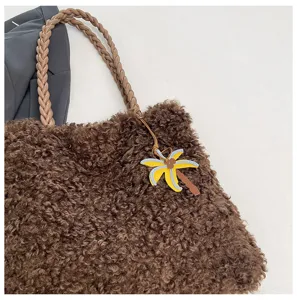 Bolso shopper marron de peluche detalle con textura suave y bonito colgante de palma.