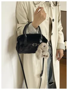 Close-up shot of the fluffy black faux fur pillow bag featuring a cute plush bunny charm.
