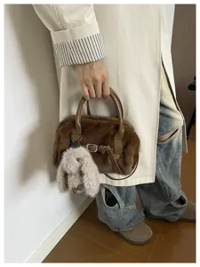 Close-up detail of soft brown plush pillow bag featuring an adorable fluffy bunny charm.