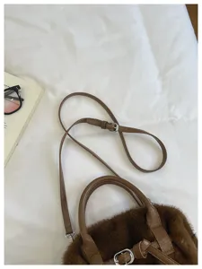 Brown plush shoulder bag detail, fuzzy crossbody bag with leather handle and adjustable strap.