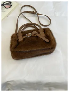 Brown faux fur detail view, showing soft texture, leather handles, and buckle strap.