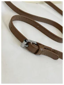 Detailed close-up view of brown PU leather bag strap featuring a sleek silver metal buckle.