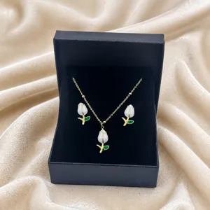 Elegant white tulip pendant necklace and earrings jewelry set with green leaf design.