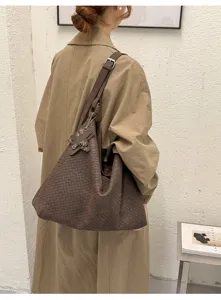 Gedetailleerd overzicht van bruine geweven schoudertas voor dames, vintage hobo design.