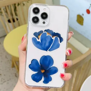Close up detail view of clear transparent phone case featuring elegant blue ink flower print.