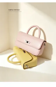 Elegant genuine leather handbag with top handle and shoulder strap, stylish minimalist design.