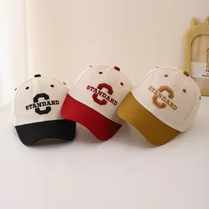 Infant baseball cap detail showcasing embroidered letter standard and contrast color brim design.