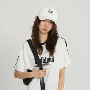 Detailed view of fashionable children baseball cap and casual white t-shirt worn by model.
