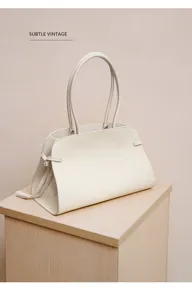 Detailed view of the elegant beige leather tote bag, featuring sturdy handles and spacious design.