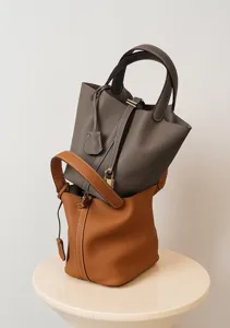 Vista detallada del bolso tipo cubo de cuero genuino con cerradura metálica elegante.