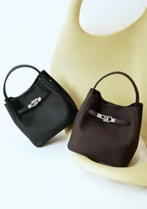 Detailansicht der hochwertigen Leder Bucket Taschen in Schwarz und Braun mit Metallschloss.