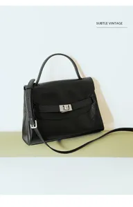 Detailed shot of a classic black leather top-handle handbag with metallic clasp.
