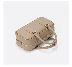 Detailed view of the stylish leather bowling handbag featuring metal hardware and double handles.