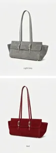 Detailed view of suede shoulder bag featuring dual slim straps and chic metal buckle design.