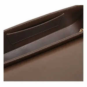 Vue détaillée de l'intérieur du sac baguette en cuir marron, montrant coutures et poche.