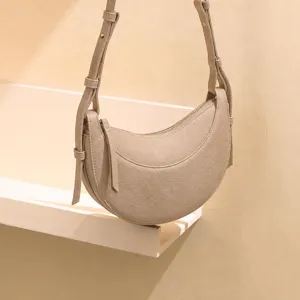 Minimalist crescent shoulder bag, stylish beige PU leather saddle bag for women daily use.