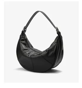 Detail view of black genuine leather crescent hobo bag, soft cowhide shoulder strap.