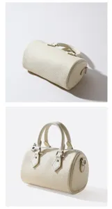 Close-up details of white leather cylindrical handbag, showing fine texture and hardware.