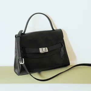 Black leather top-handle commuter handbag with shoulder strap and flap closure for women.