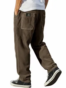 Détail de pantalon marron en velours côtelé pour homme avec poche arrière et étiquette noire.