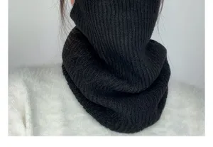 Detailed close-up of a cozy black knitted neck gaiter showing soft ribbed texture.
