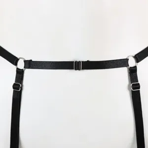 Detailed close-up shot of black elastic strap body harness with metal rings and adjusters.