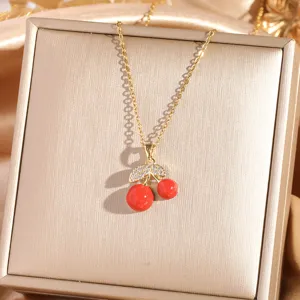 Detail shot of the exquisite gold cherry necklace with sparkling zircon and vibrant red fruit