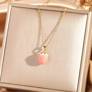 Close-up of gold chain necklace with pink strawberry pendant, showing fine jewelry craft.