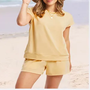 Close-up van de casual gele loungewear set, bestaande uit top en korte broek op het strand.